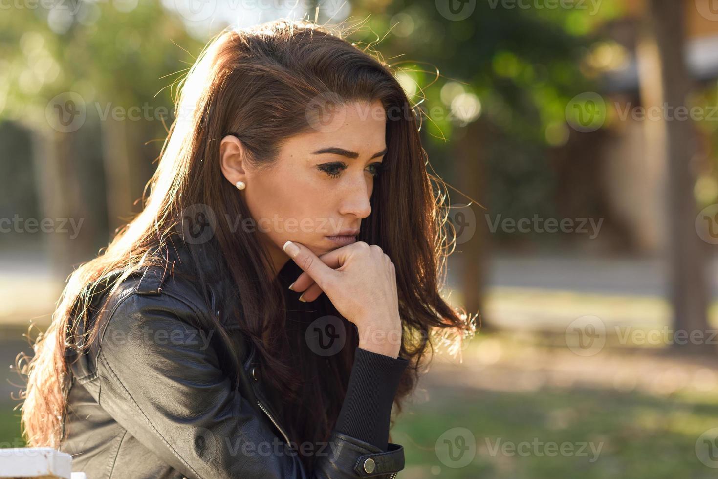 mujer pensativa sentada sola al aire libre foto