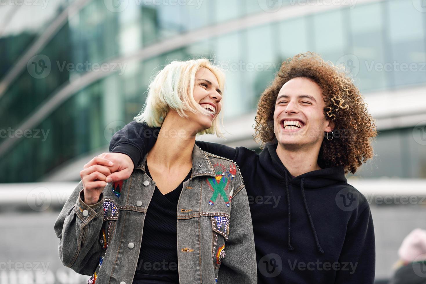 feliz, pareja joven, reír, en, urbano, plano de fondo foto