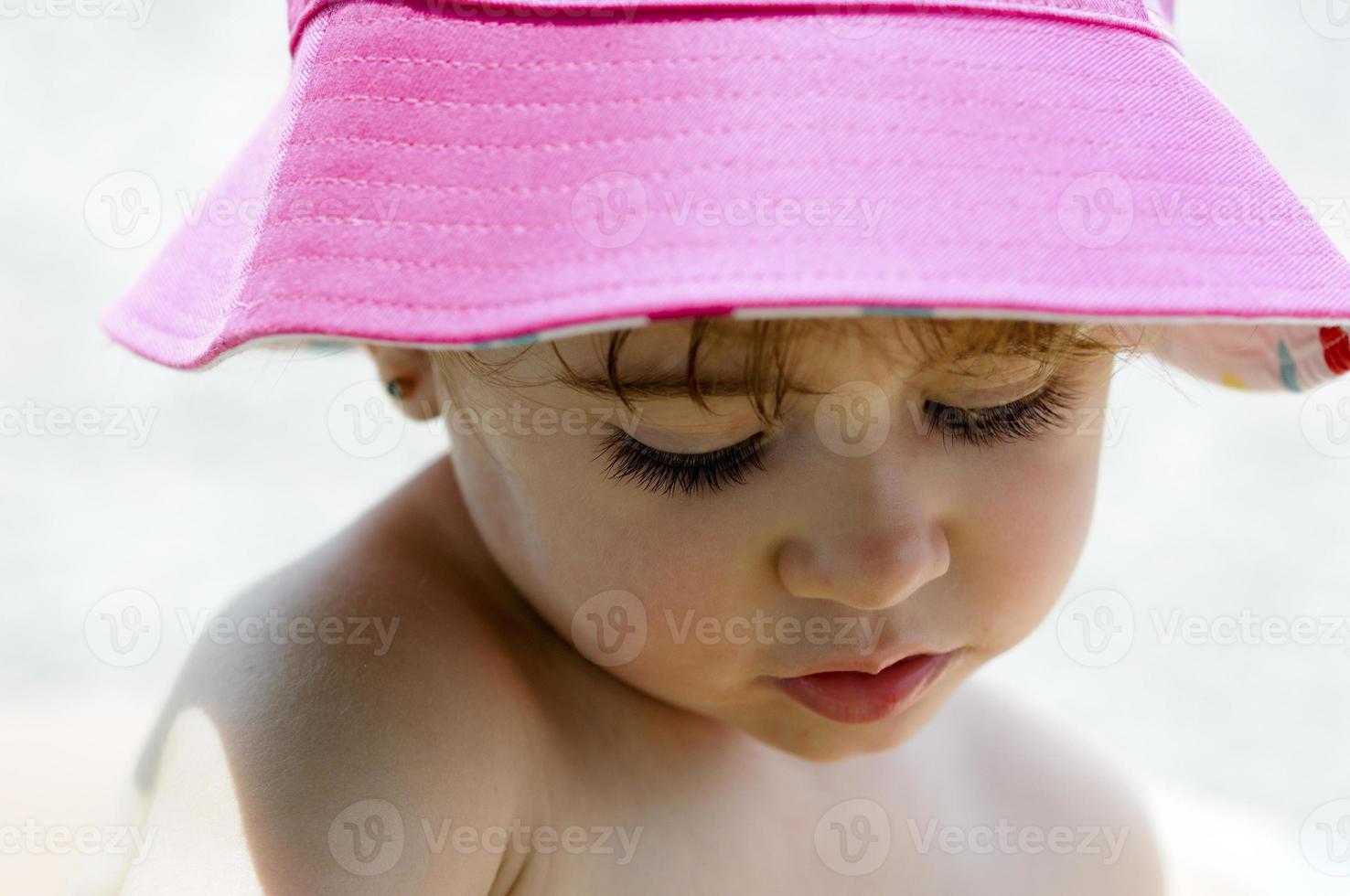 Close-up potrait de adorable niña vistiendo sombrero para el sol foto