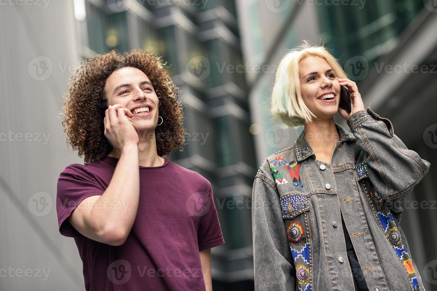 Happy couple using smartphone in urban background. photo