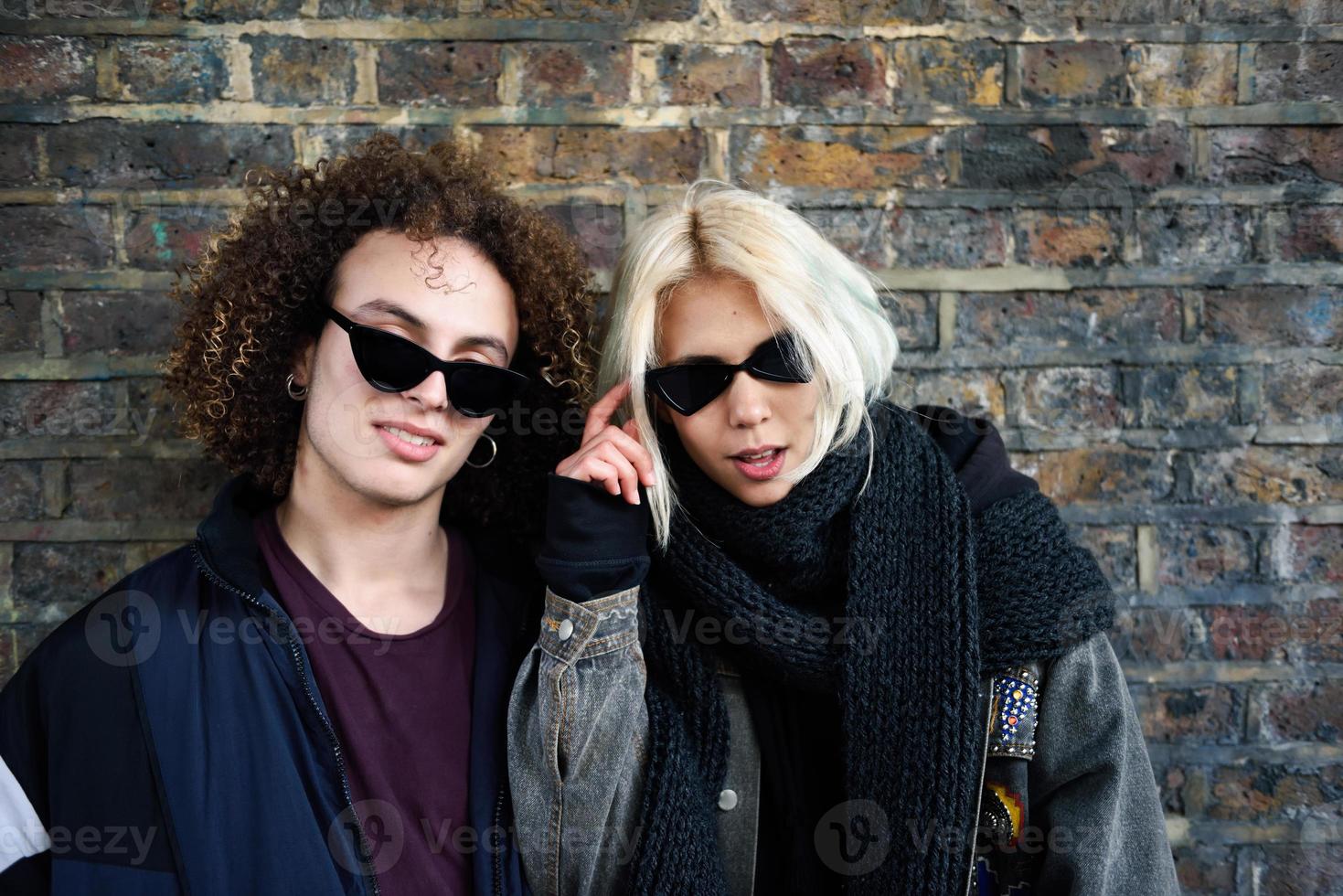 Pareja joven disfrutando de Camden Town en frente de una pared de ladrillos típica de Londres foto