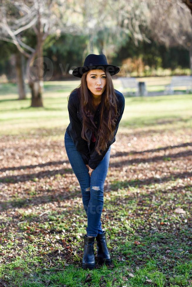 Portrait of young woman smiling in urban park photo