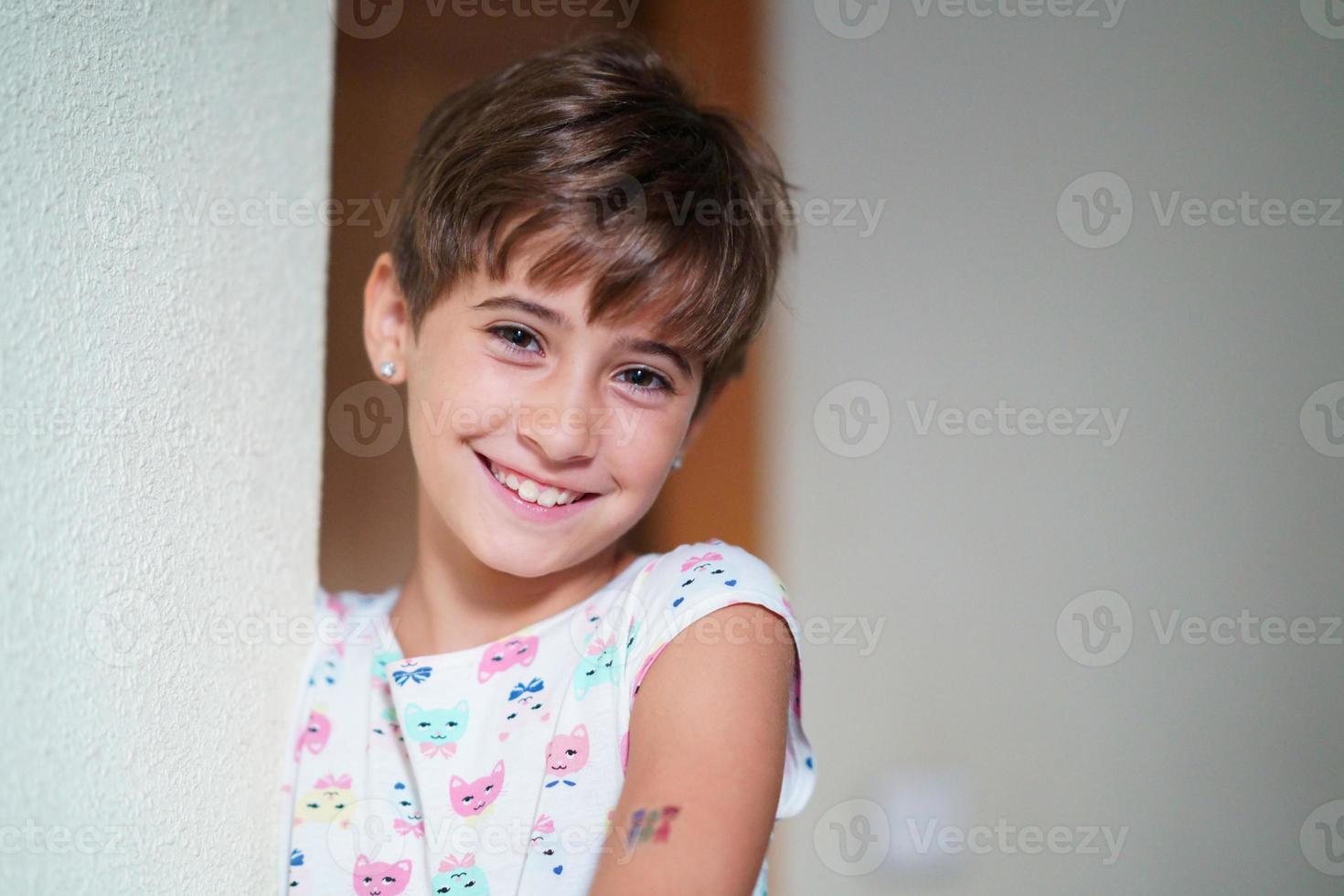 adorable niña, de ocho años, mirando sonriendo a la cámara. foto