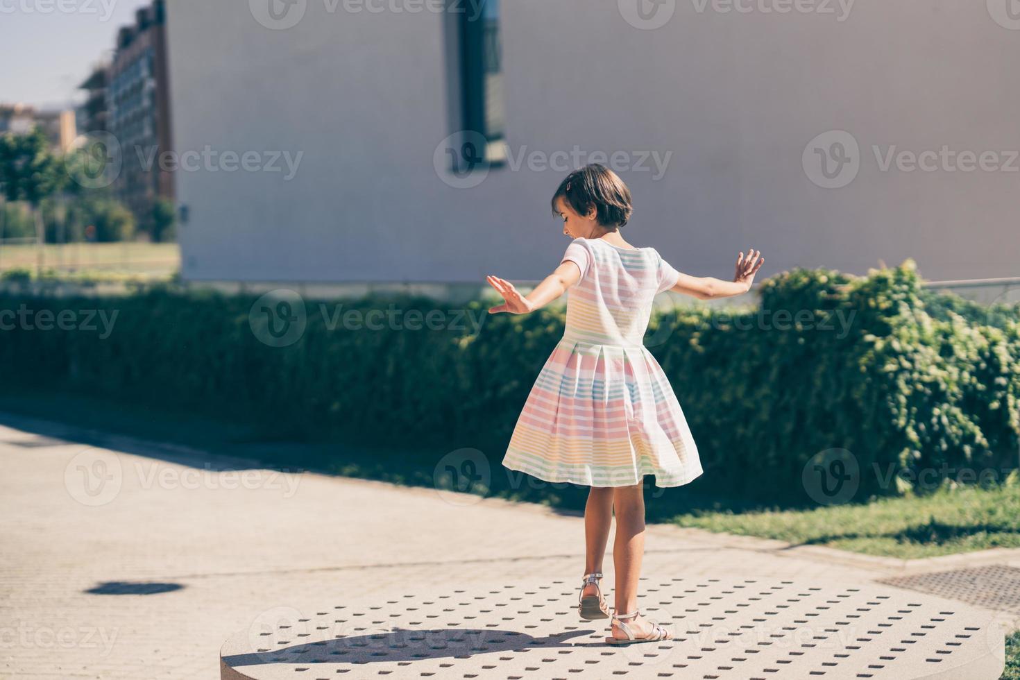 Happy 9-year-old girl in a pretty dress playing photo