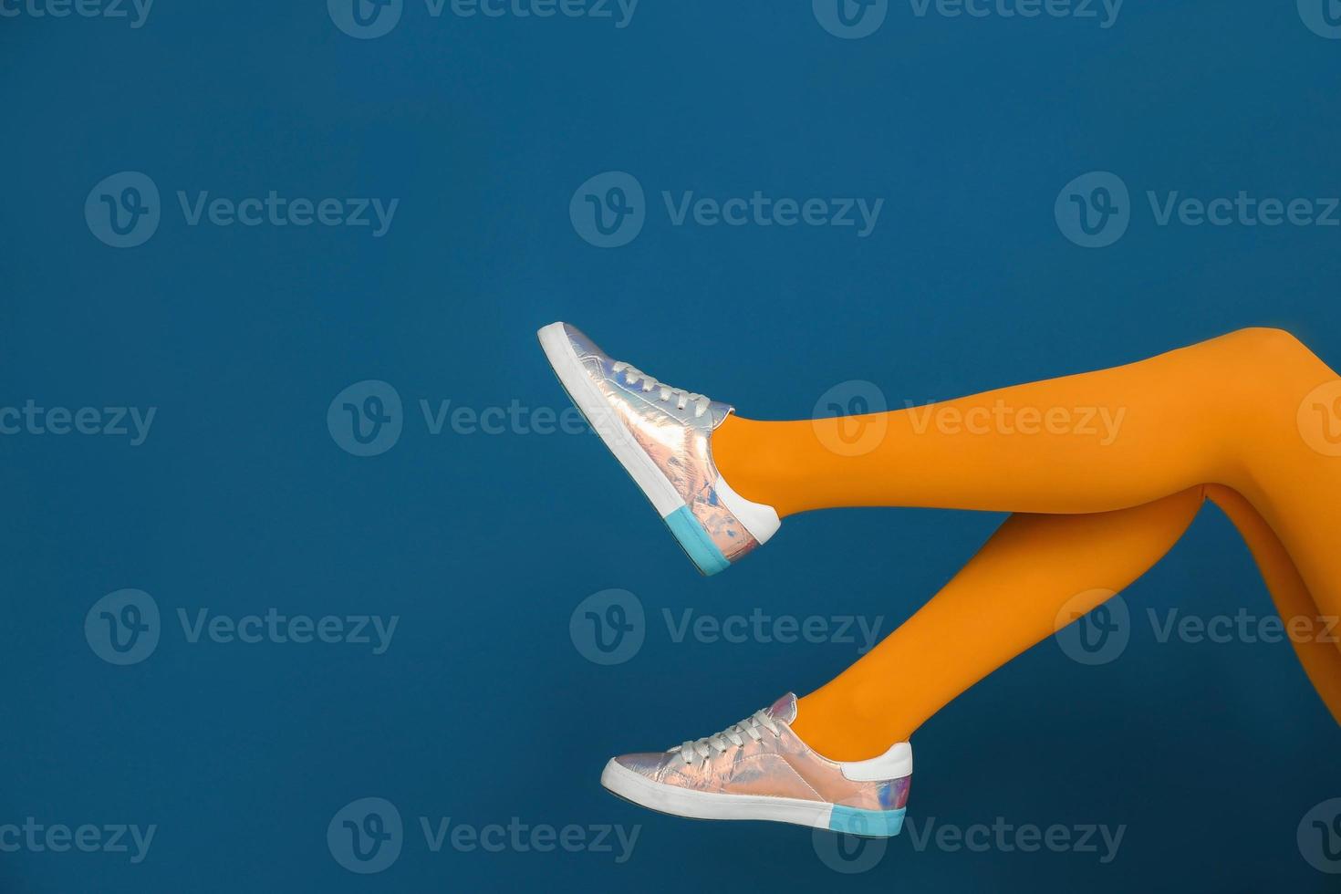 Legs of beautiful woman in stylish shoes on color background photo