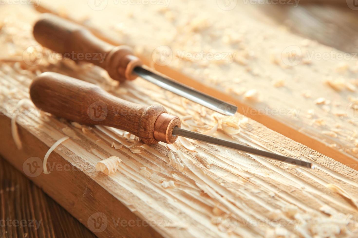 Chisels, wooden boards and sawdust in carpenter's workshop photo