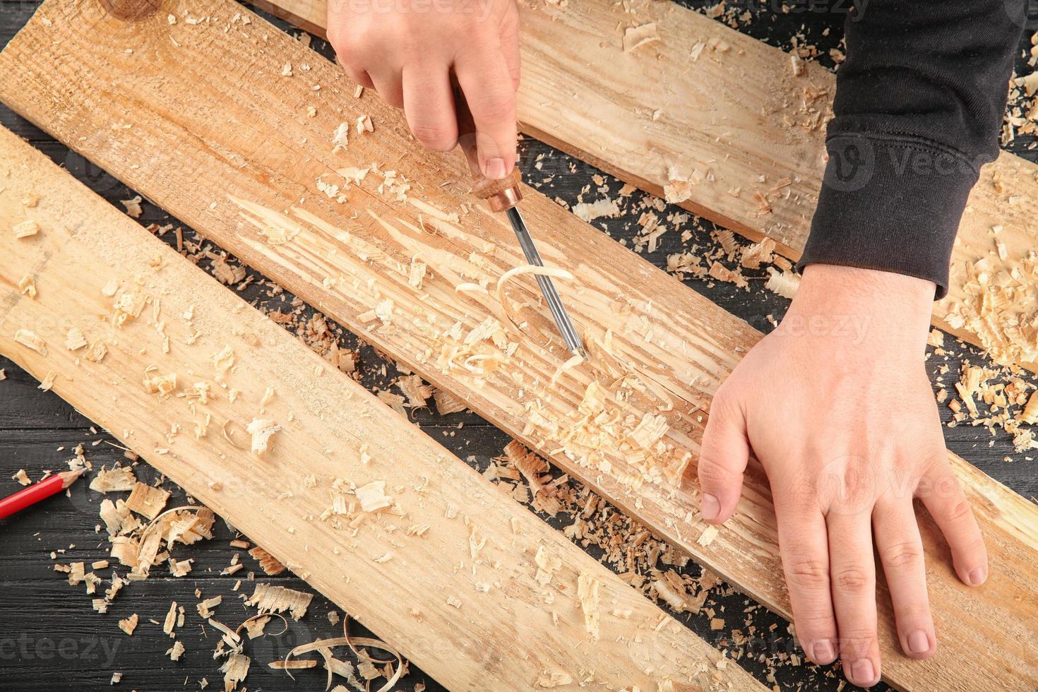 Carpenter working with chisel, closeup photo