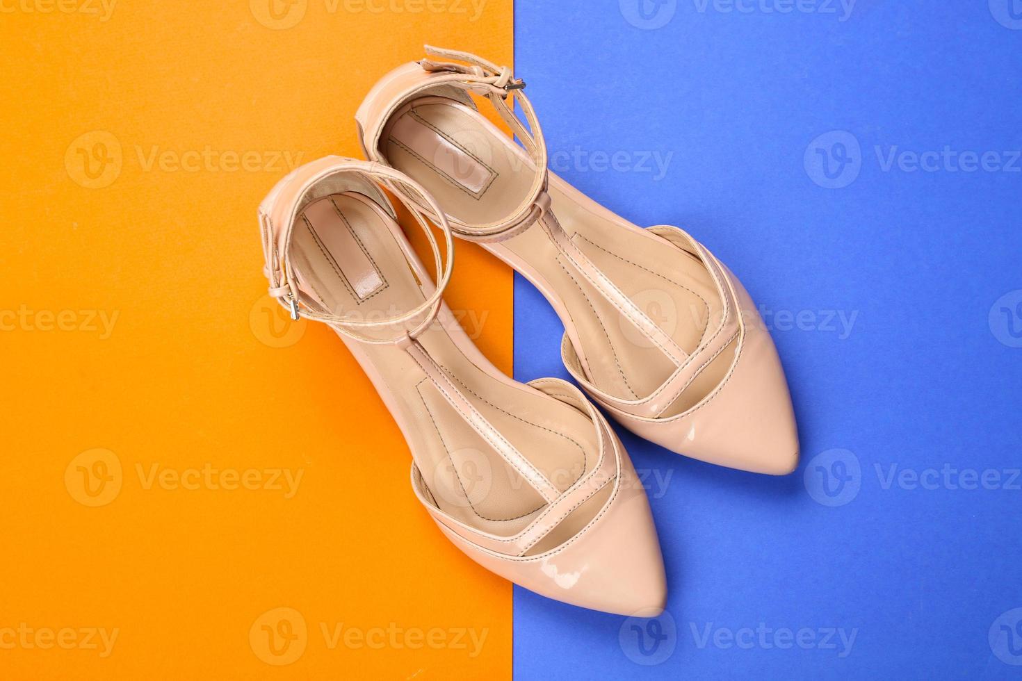 Elegant female shoes on color background photo