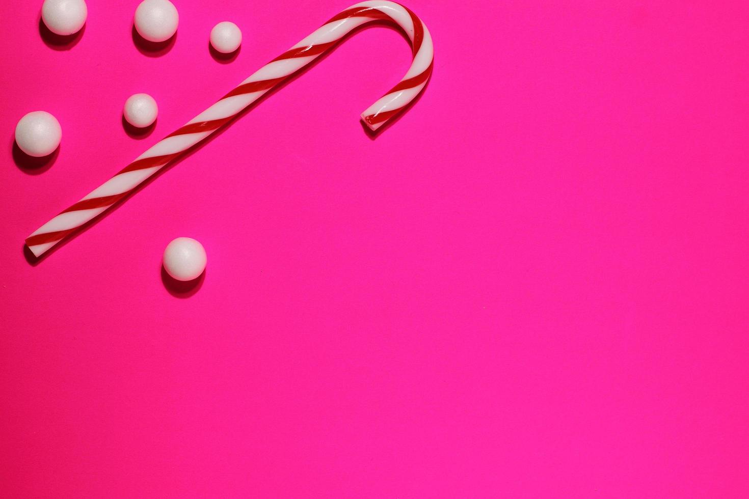 Red striped cane, Christmas candy on magenta background photo