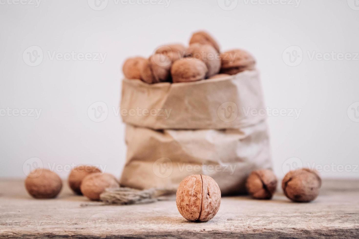 Nueces en una bolsa de papel sobre una vieja mesa rústica foto