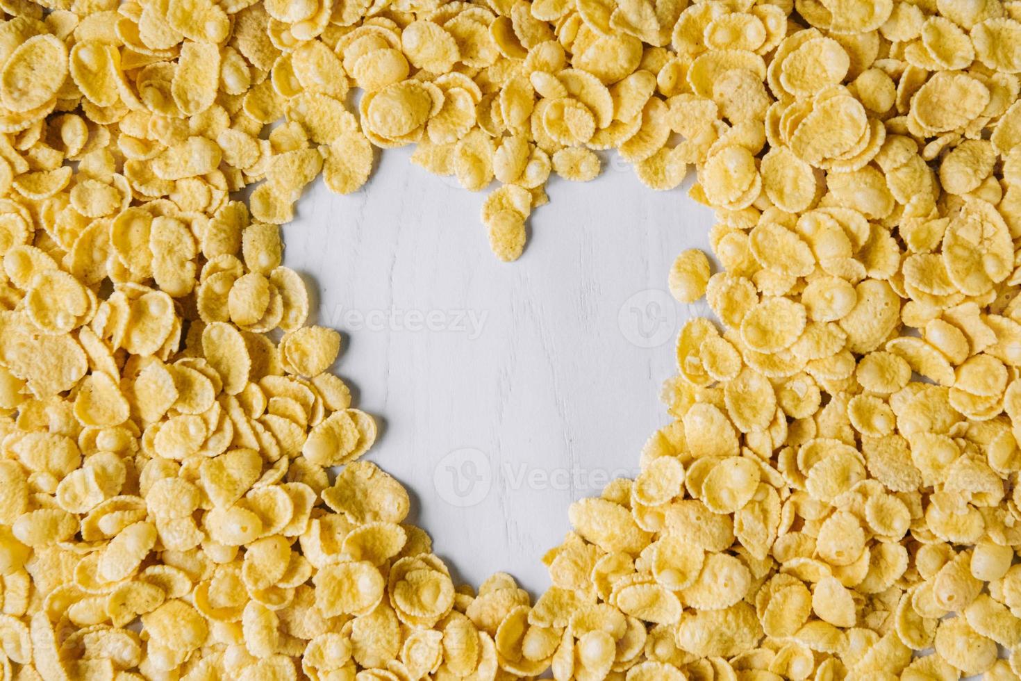 Frame in shape of heart made with cornflakes on white background photo