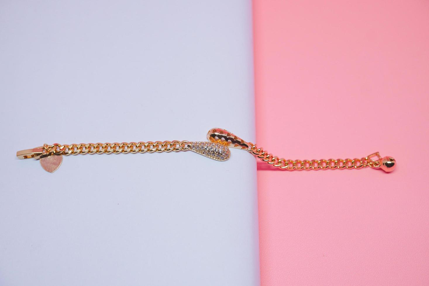 photo of a girl's bracelet with a kinky pendulum motif on a pink background