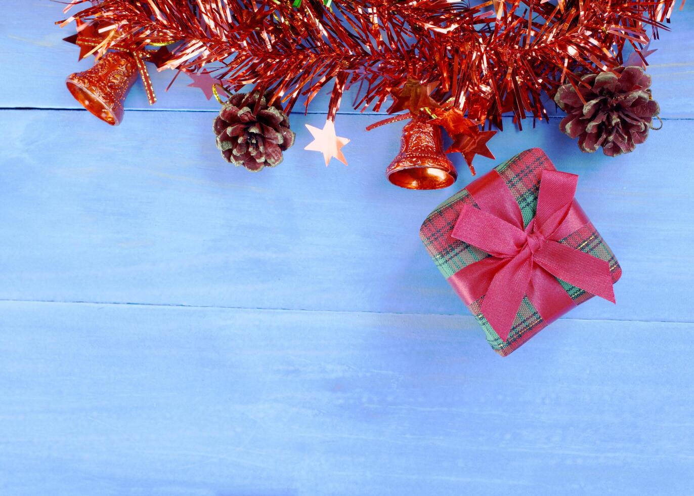 Adornos navideños con caja de regalo sobre fondos de madera de color azul pastel arriba. lugar para tu texto foto