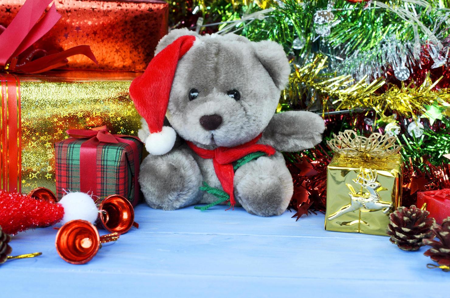 Muñeco de peluche con gorro de Papá Noel y fondos de adornos navideños foto