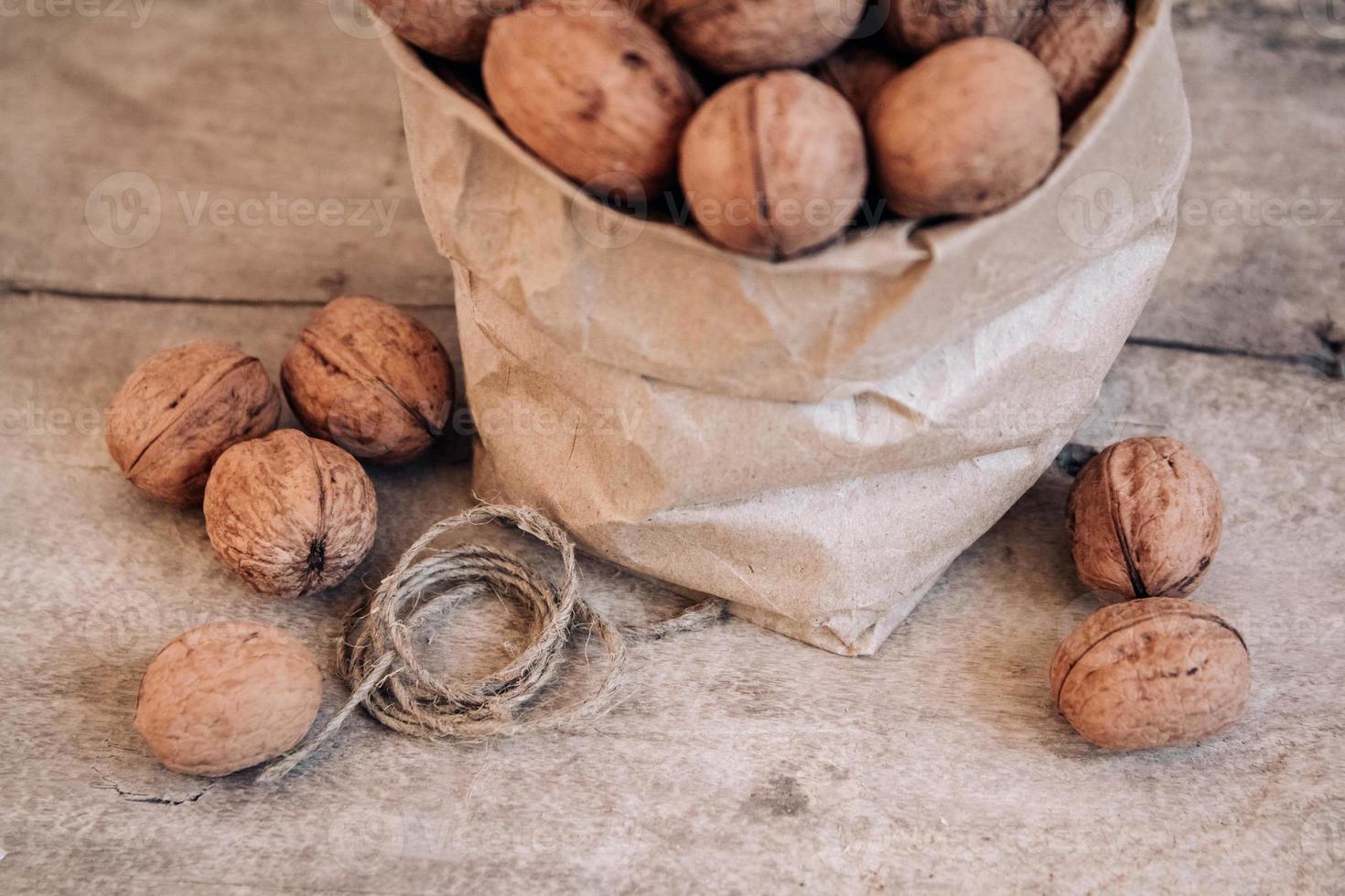 Nueces en una bolsa de papel sobre una vieja mesa rústica foto