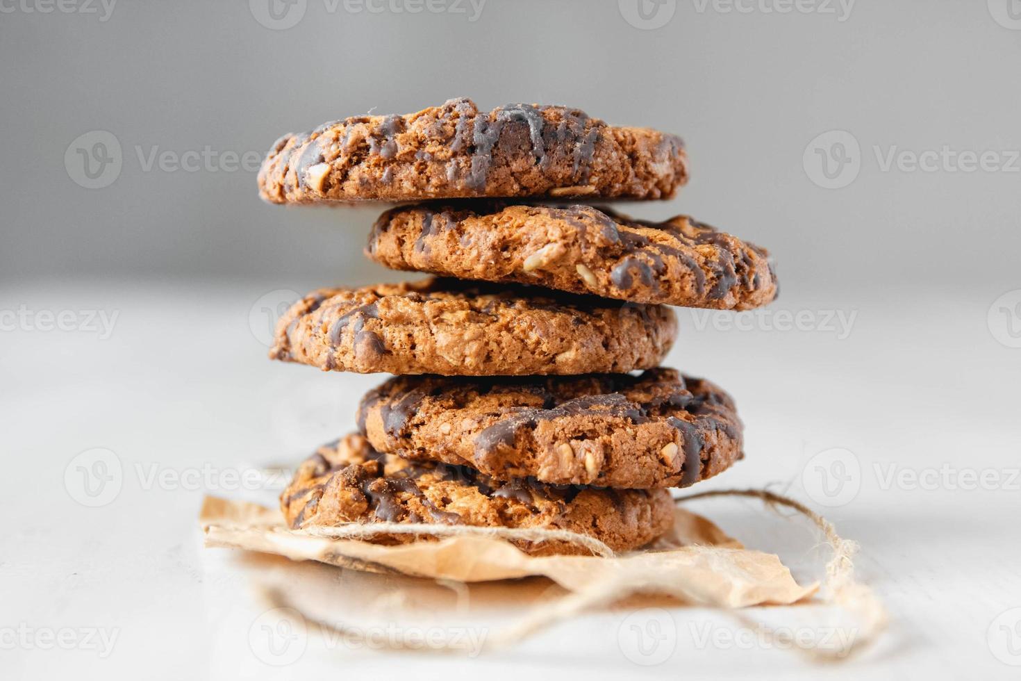 Deliciosas galletas con chispas de chocolate sobre fondo blanco de mesa foto