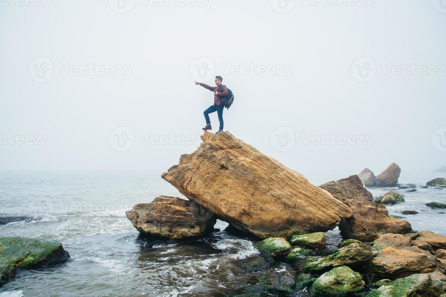 Man stand on cliff edge alone enjoying aerial view backpacking photo