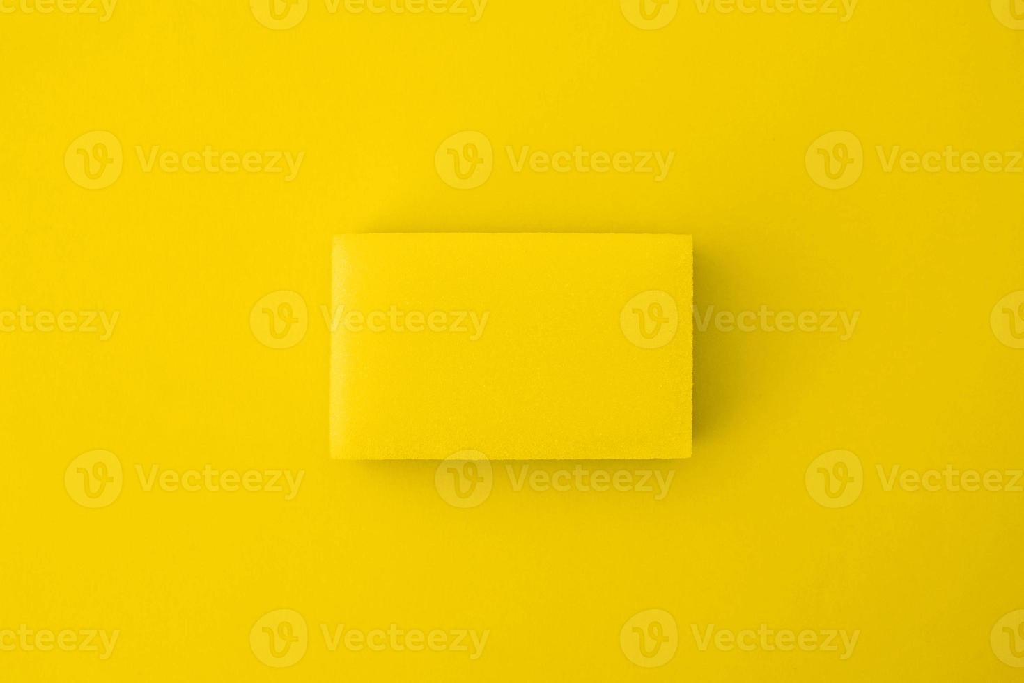 Yellow cleaning sponge on a yellow background photo