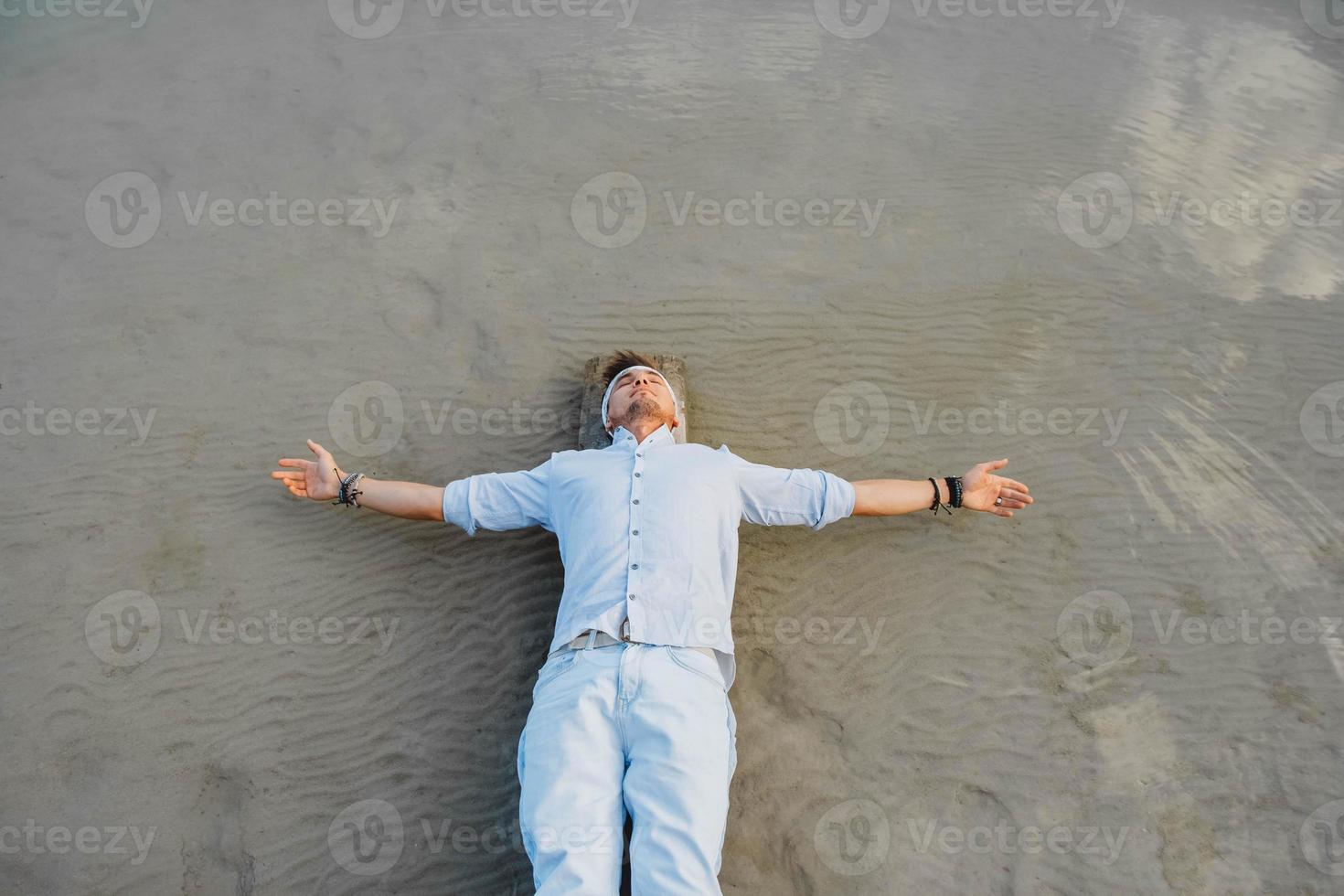 Man lying on wooden bridge against background of water photo