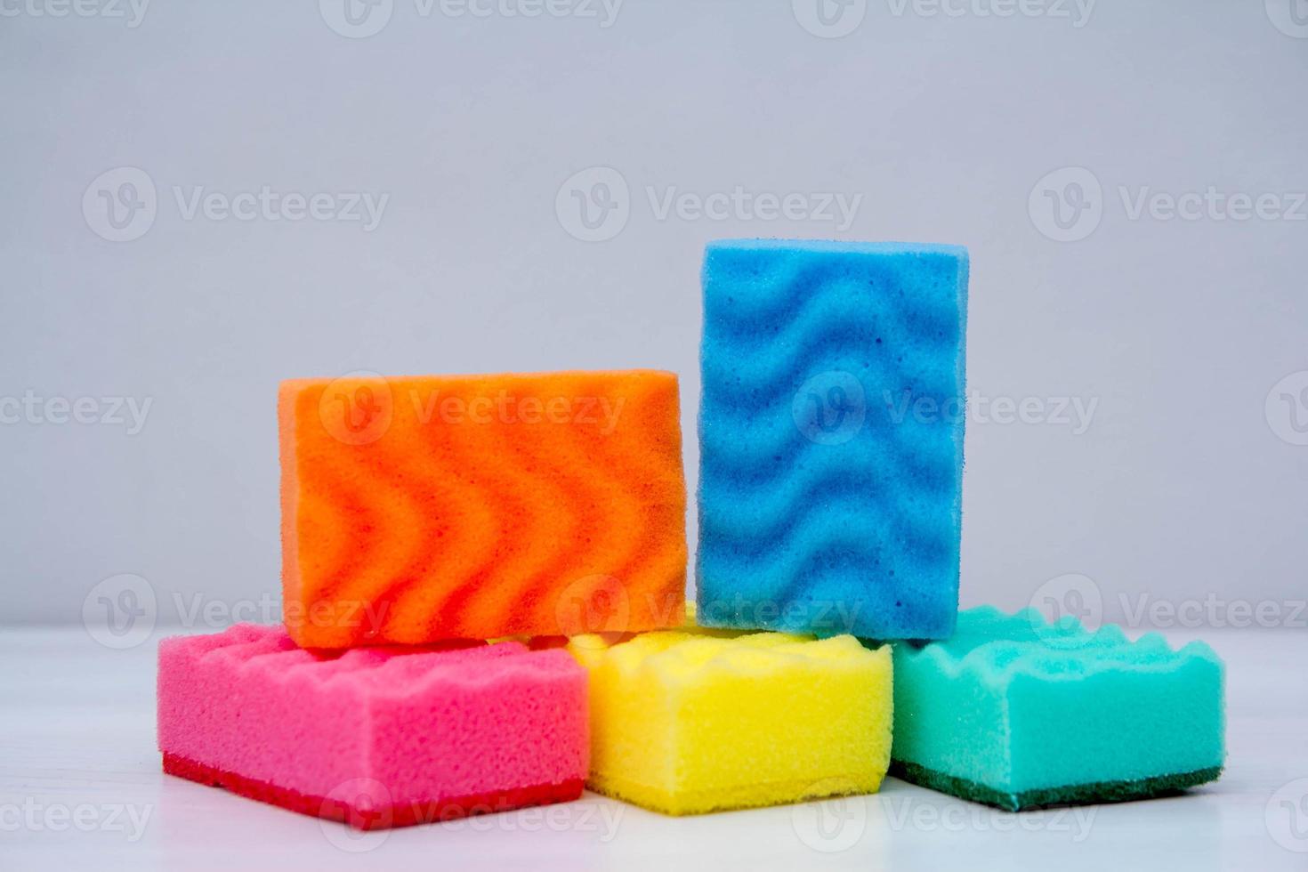 Multicolored sponges for cleaning and washing dishes on table photo