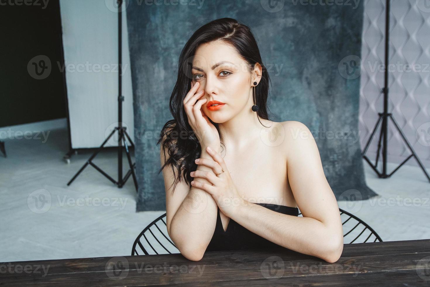 Portrait of woman sitting at table on dark gray copy space background photo