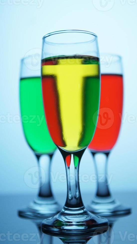 Closeup photo of drink in a glass on a bokeh blur background of colored drink glasses