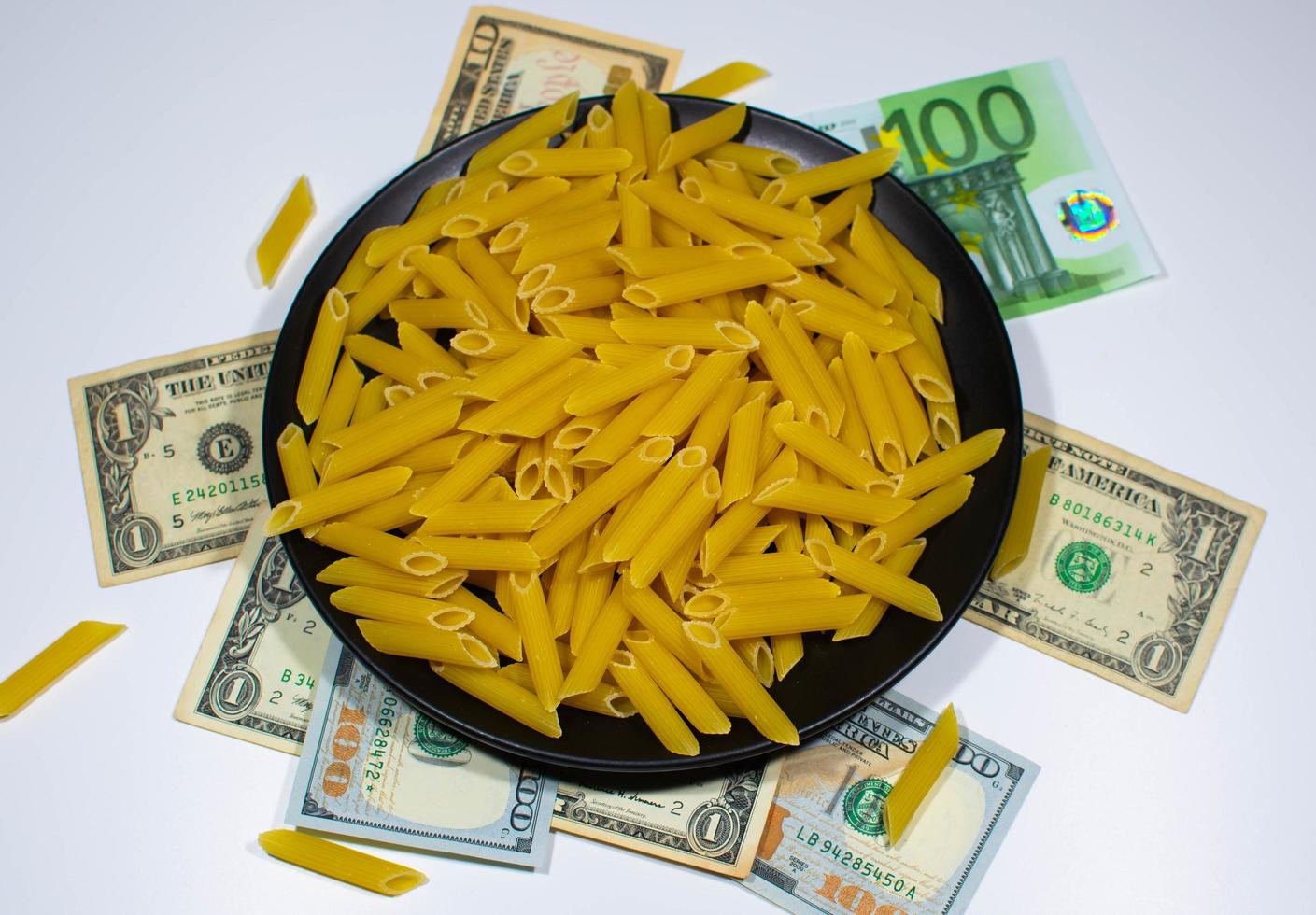 Pasta on a black plate under which lies money photo