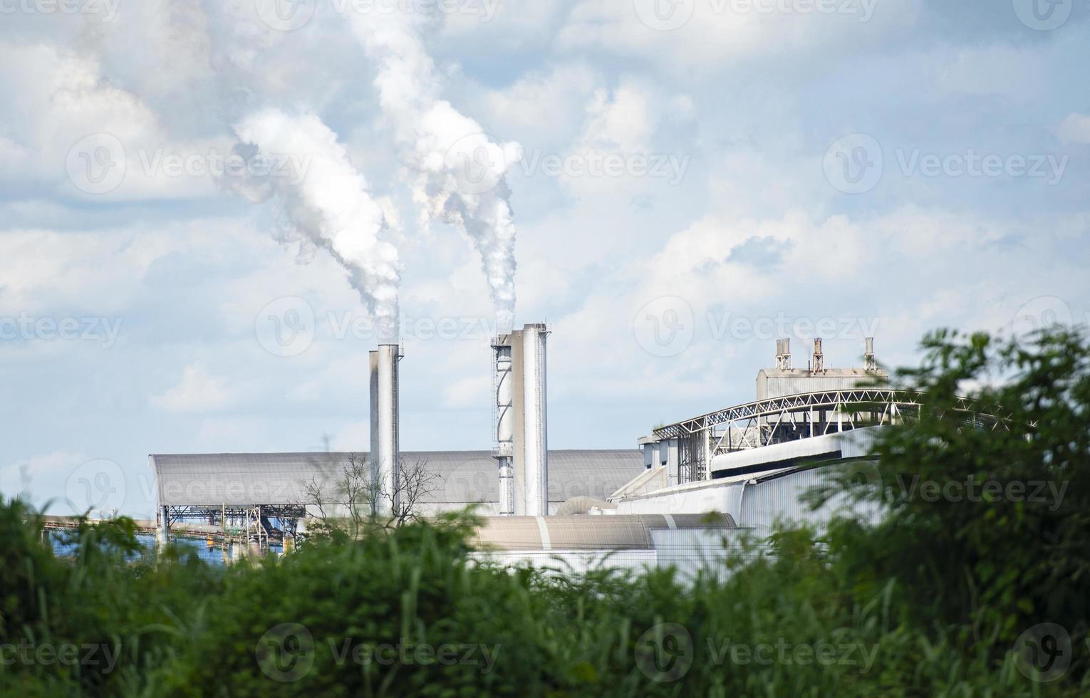 Un humo denso y denso que sale de un enorme humo blanco que sale de las chimeneas o los tubos de escape de las fábricas emiten vapor de agua que se condensa en una nube blanquecina antes de evaporarse. foto