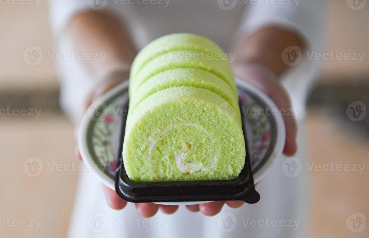 cake roll on plate - woman served green cake roll pandan with cream photo