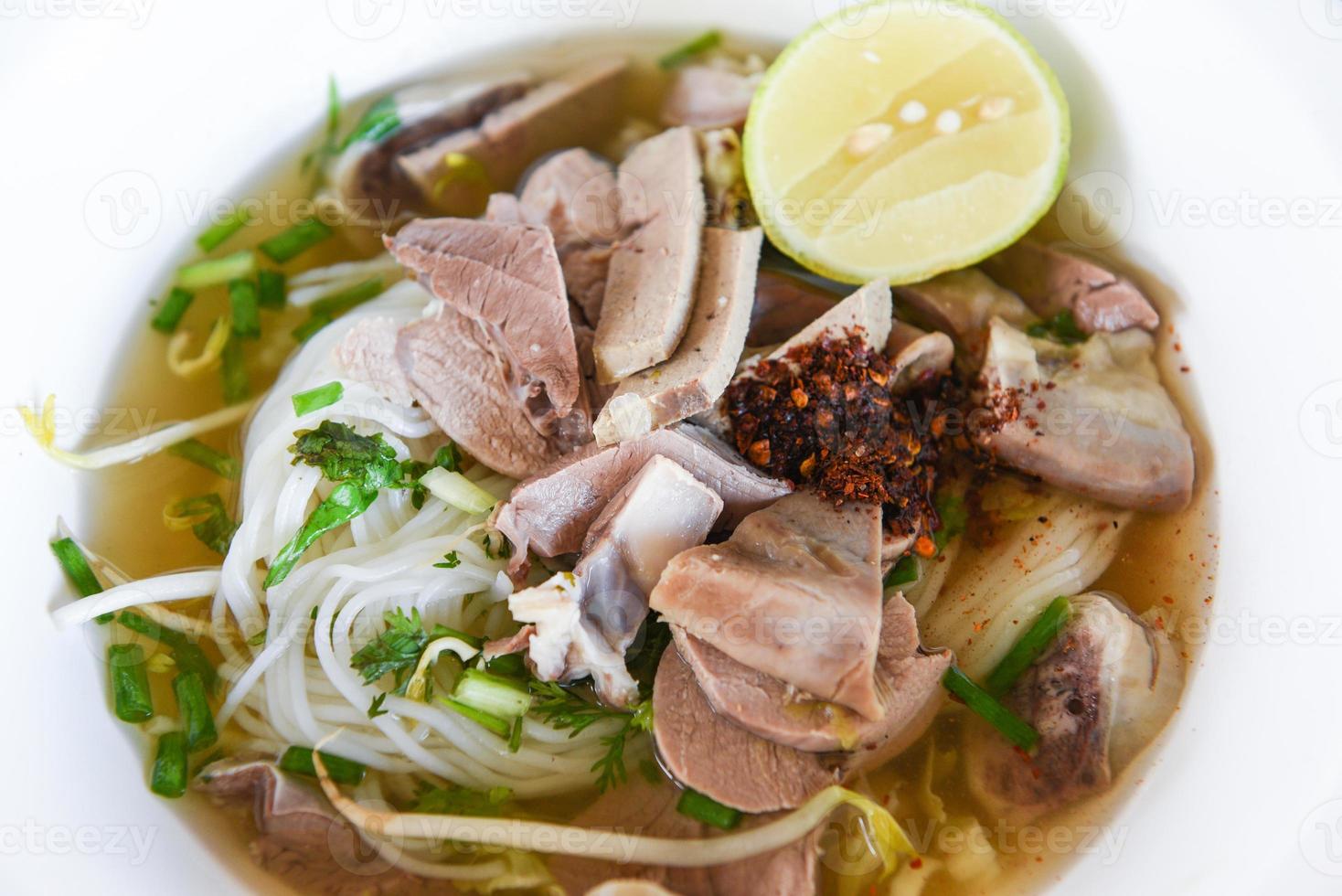 vermicelli noodles soup spicy with pork stew vegetable and lemon in bowl traditional thai and chinese style food of asia , Pork offal , Liver pork intestines - delicious noodles bowl photo