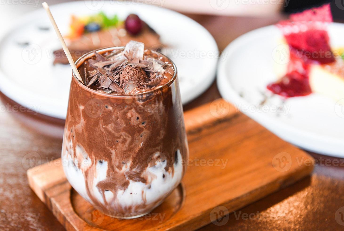 cocoa drink and chocolate - tasty milk shake with ice cocoa in glass on wood background photo