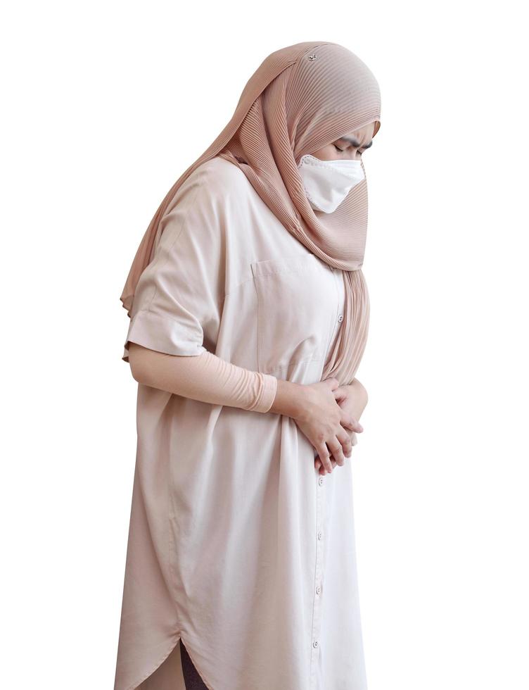 Muslim woman wearing a surgical mask feeling sick on white background photo