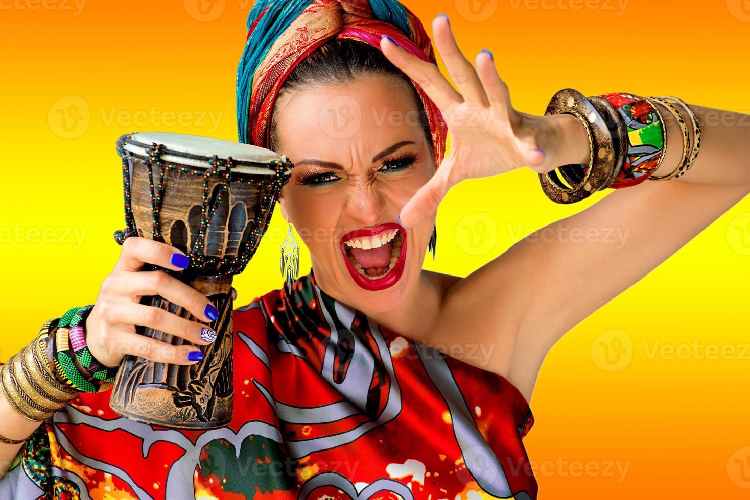 portrait of screaming young attractive woman singer in african style with drum on colorful background photo