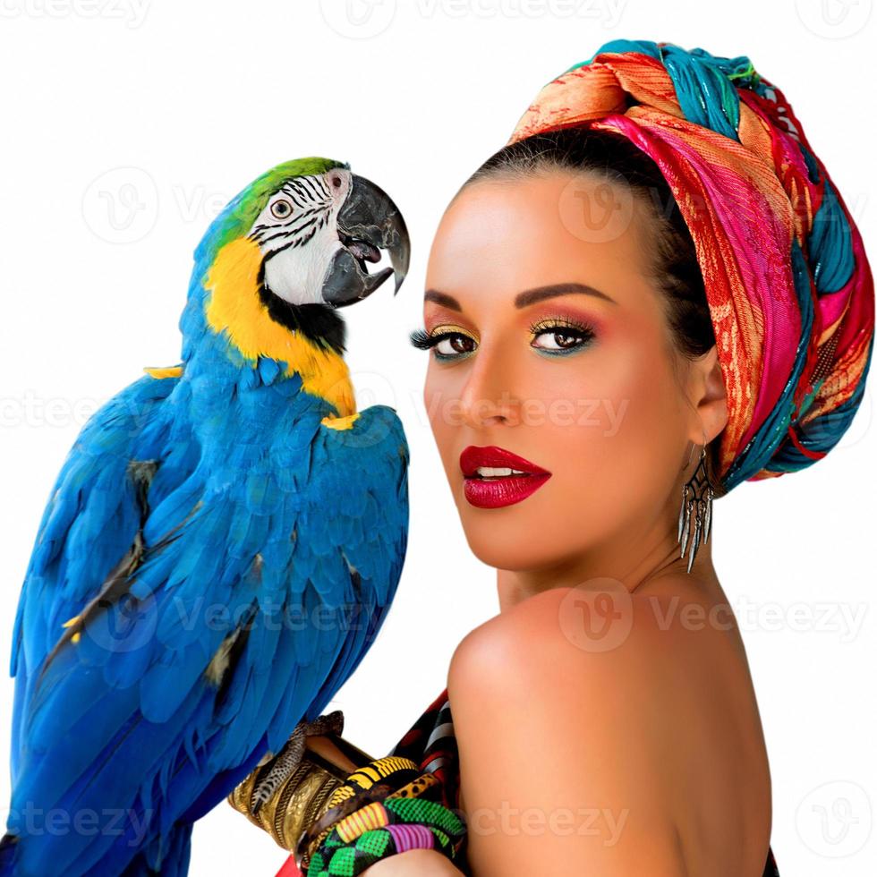 Portrait of young attractive woman in african style with ara parrot on her hand on colorful background photo