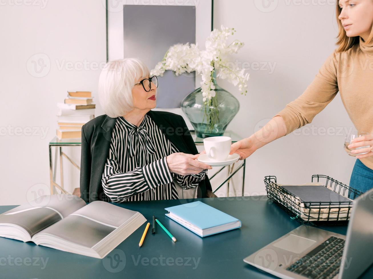 young assistant brought a coffee to the boss in office. Business, communication, work, ages, collaboration, mentoring concept photo