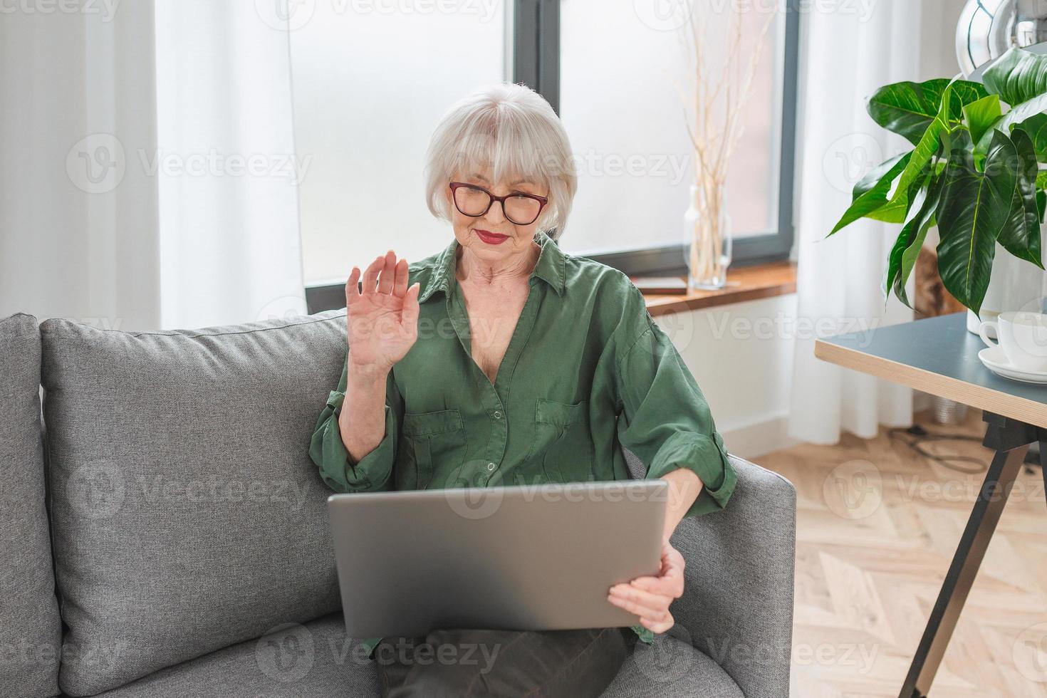 senior friendly woman entrepreneur work from home. Talking on the phone work with lap top. Business, self employed, senior woman concept photo