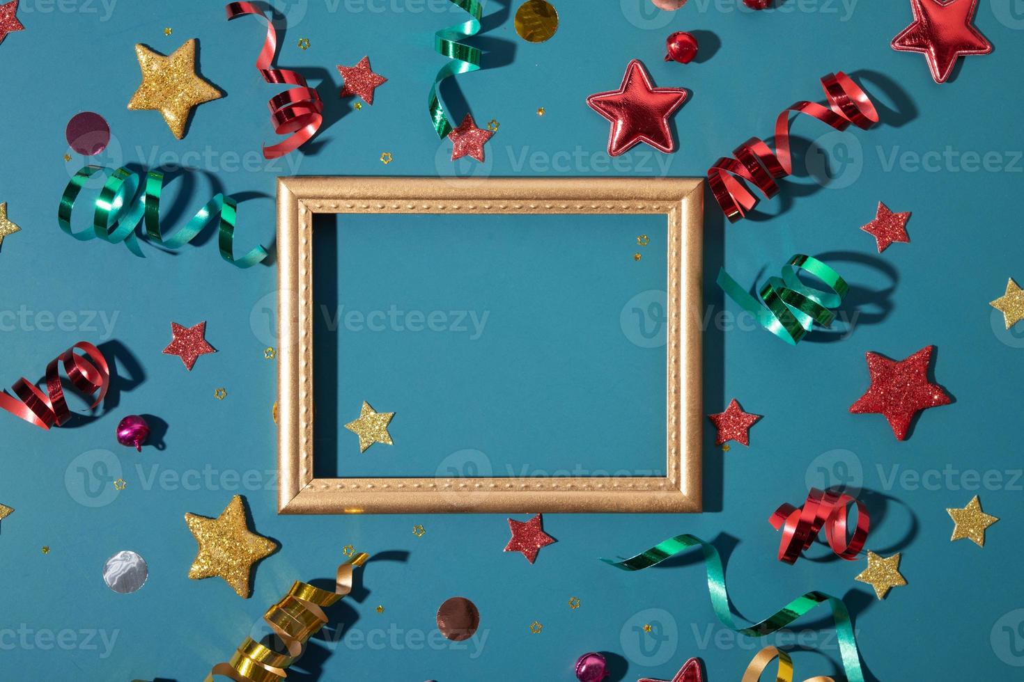 Top view golden frame with shiny festive stars, streamers, sparkles with copy space photo