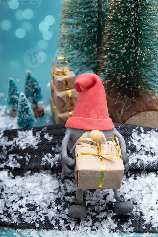 Scandinavian gnome sitting with Christmas gifts. Creative modern holiday concept photo