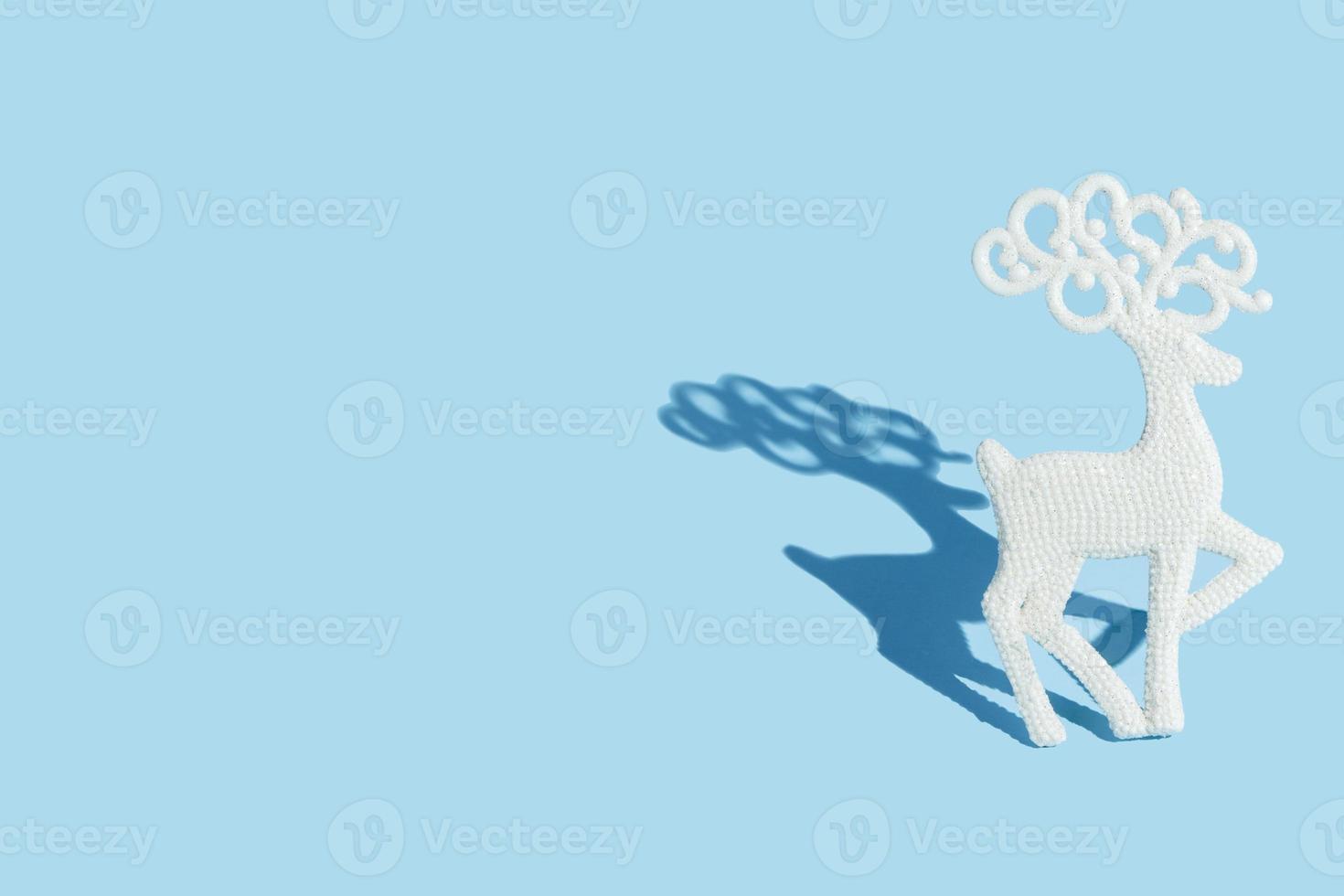 ciervos de navidad en brillo sobre un fondo azul con sombra dura con espacio de copia foto