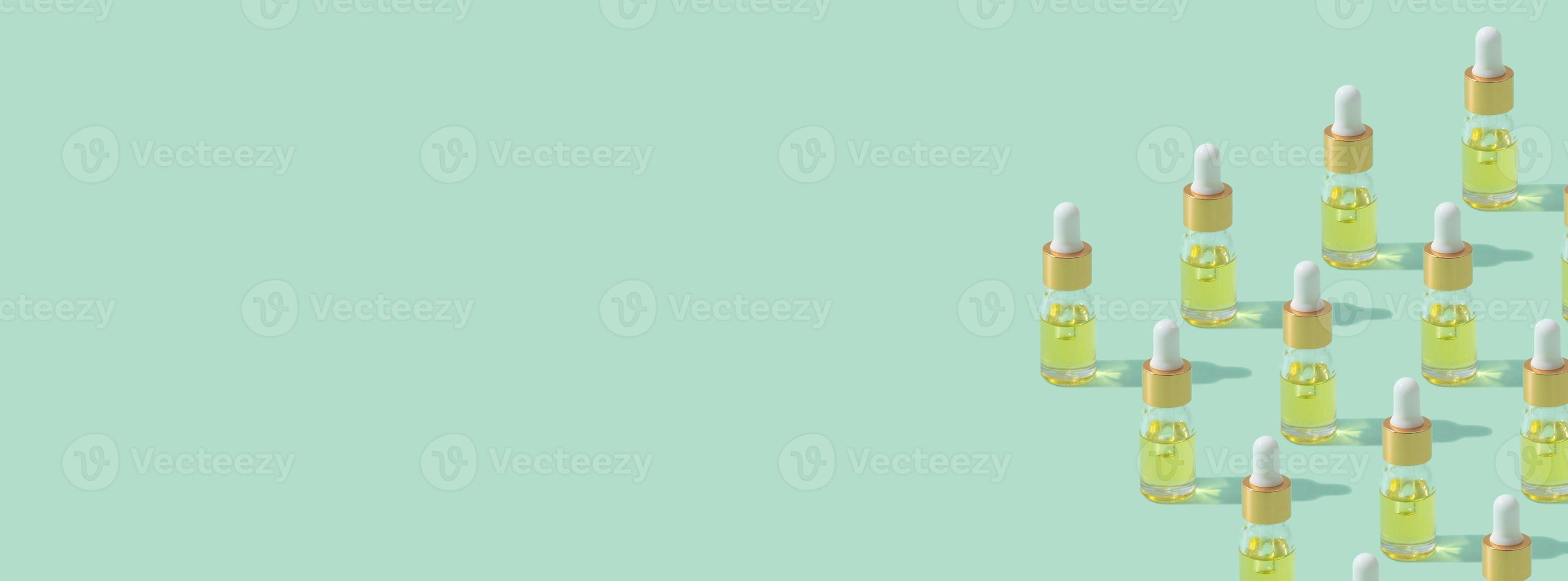 Banner with dropper bottles pattern cosmetic oil or serum with pipette on mint background copy space photo