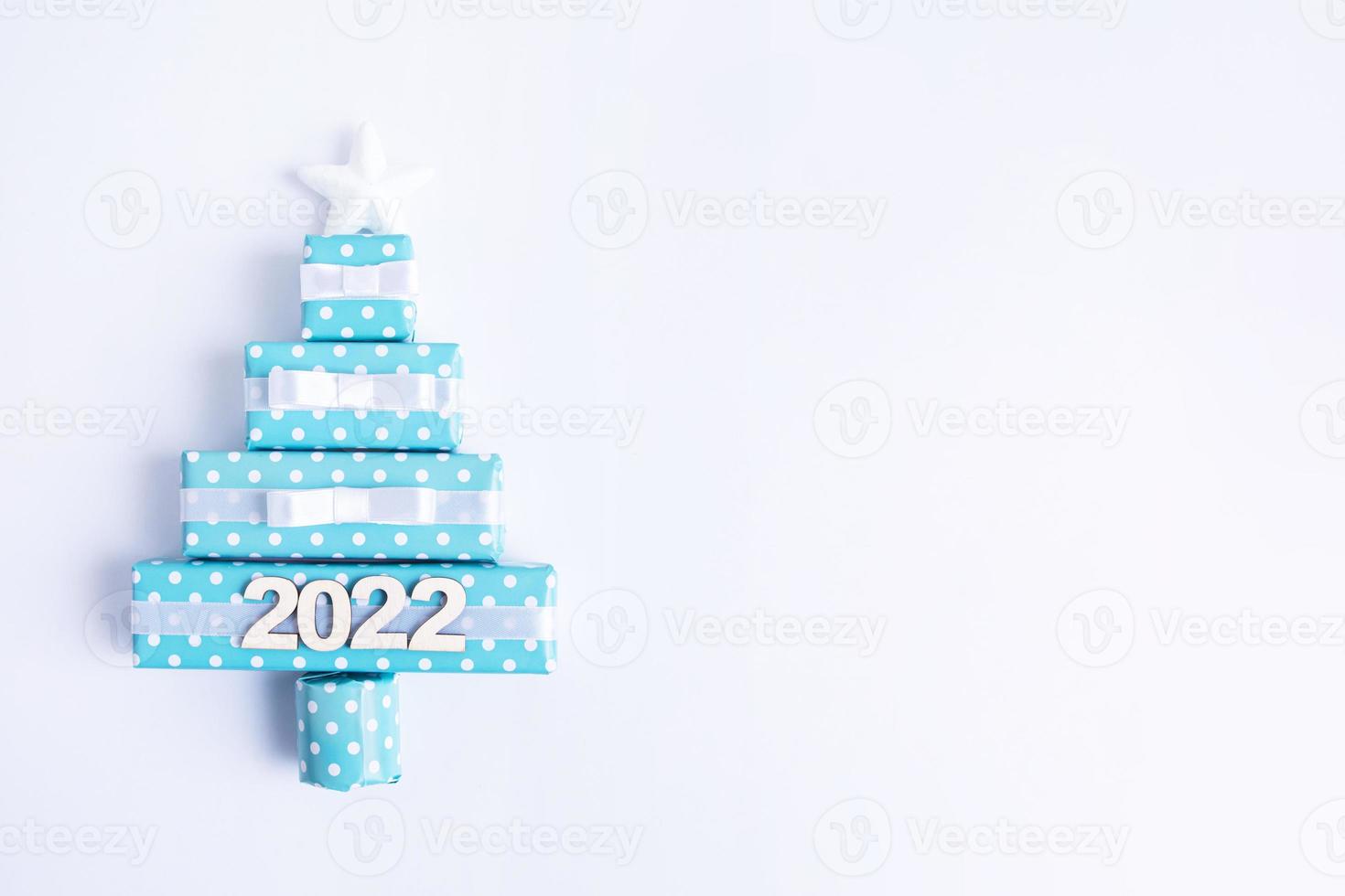 Blank greeting card with creative abstract Christmas tree made of gift boxes and 2022 New Year photo