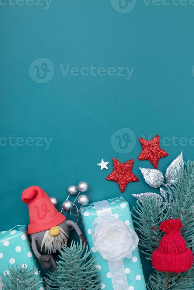 Tarjeta de felicitación de Navidad con decoraciones de vacaciones de invierno laicas planas sobre fondo turquesa con espacio de copia foto