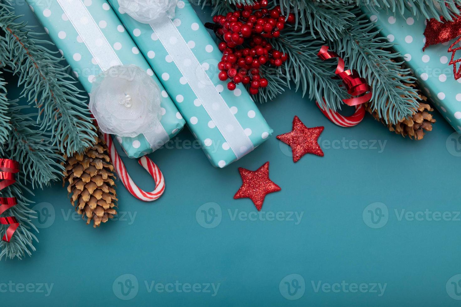 Fondo plano de Navidad con regalos, bayas y pino sobre fondo turquesa foto