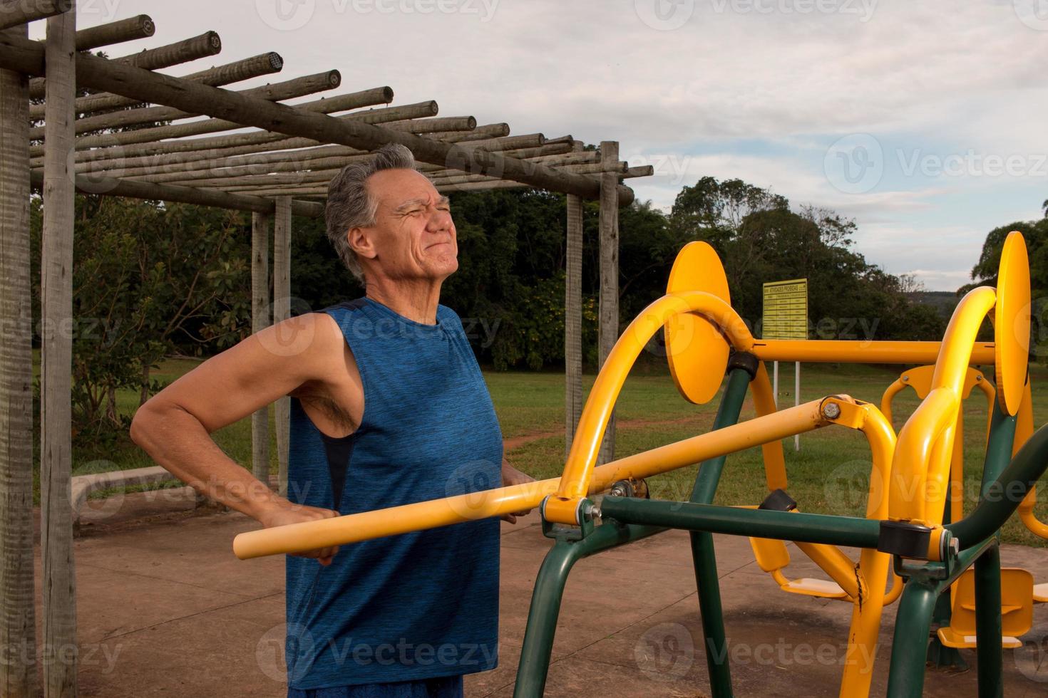 Senior Mature Man working out at an outdoor fitness park in Parque Das Garcas, Brasilia photo