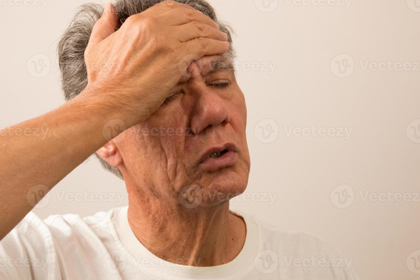 Senior Man in pain with Headache with hand on forehead photo