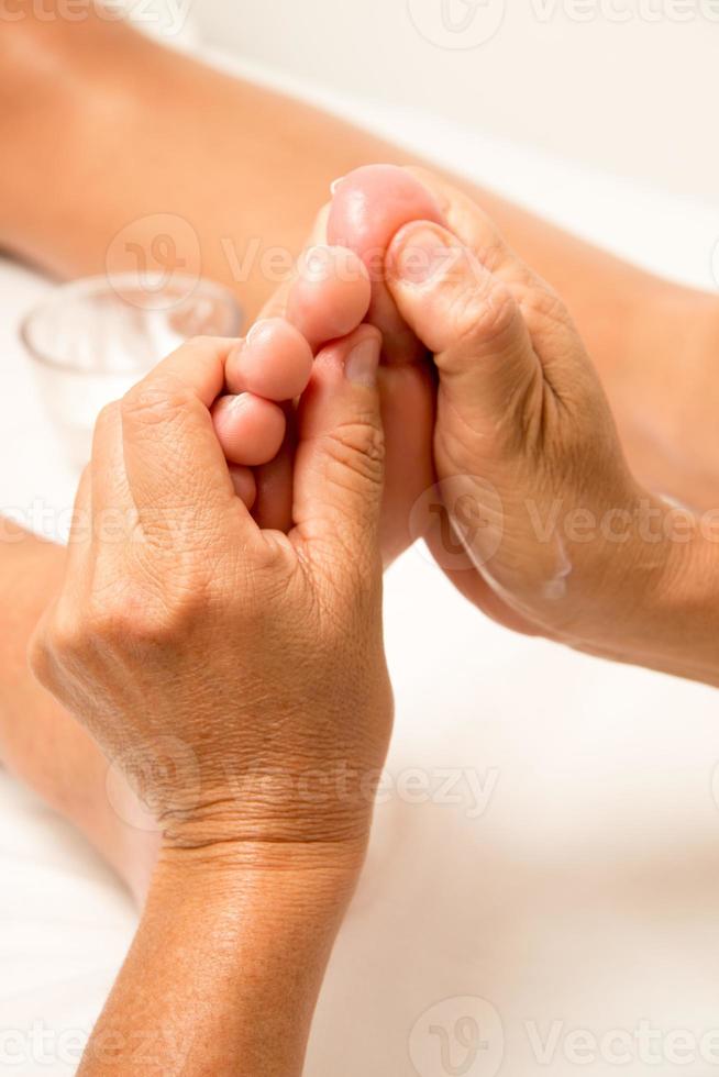 terapeuta de masaje masajeando un pie de señoritas foto