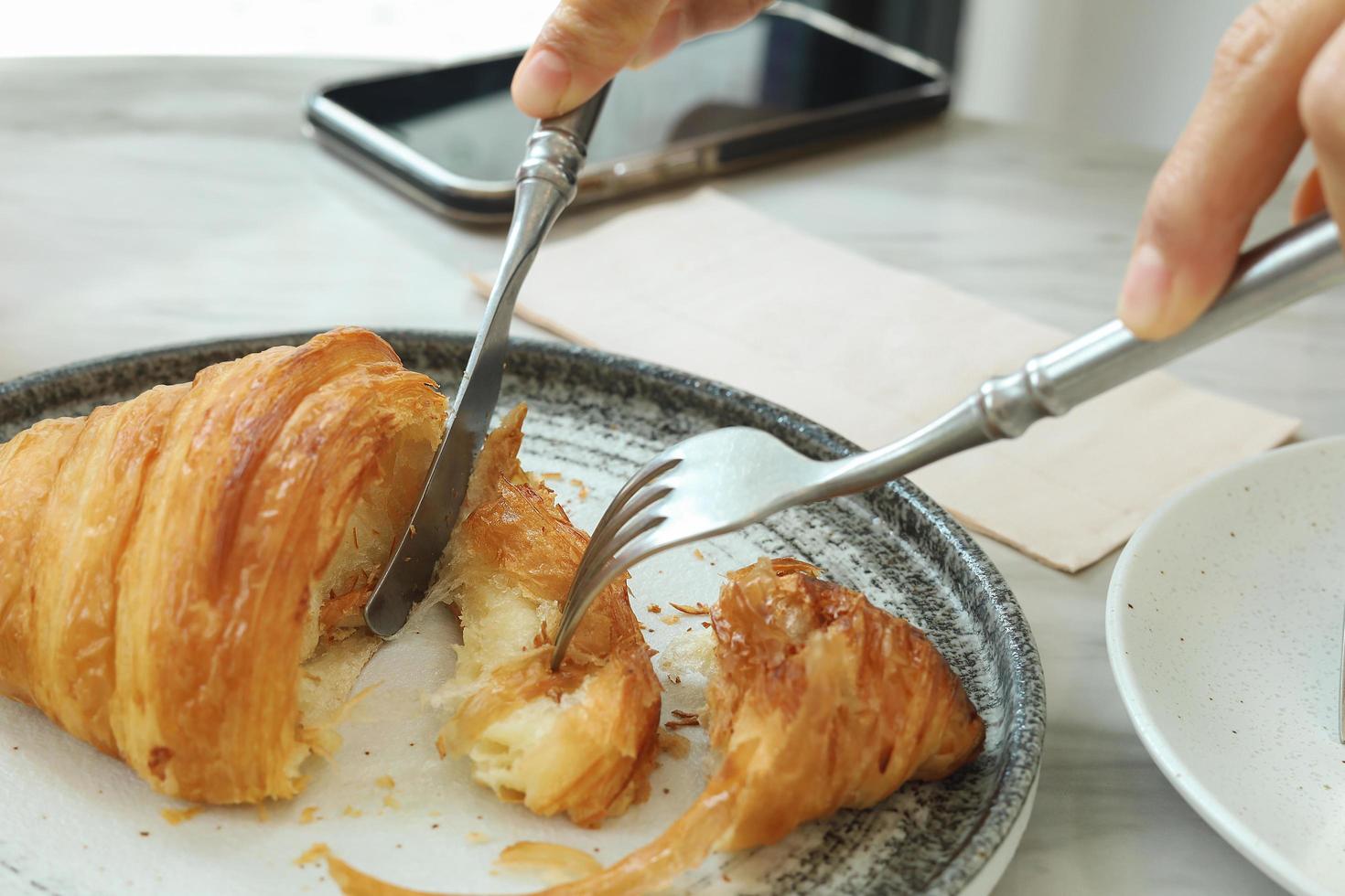 Croissant recién horneado brillante en la cafetería. foto