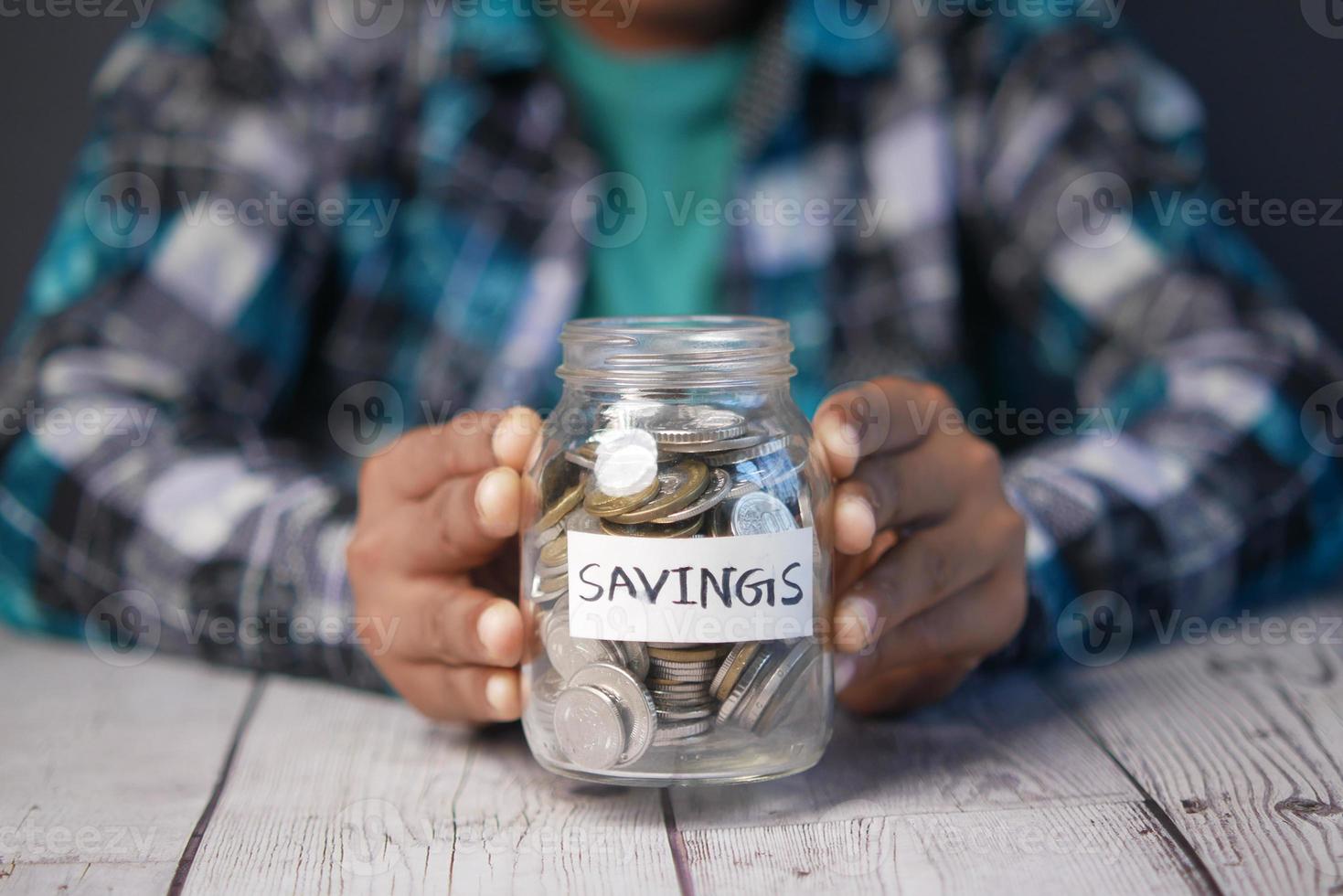 child boy hand hold a saving coins jar photo