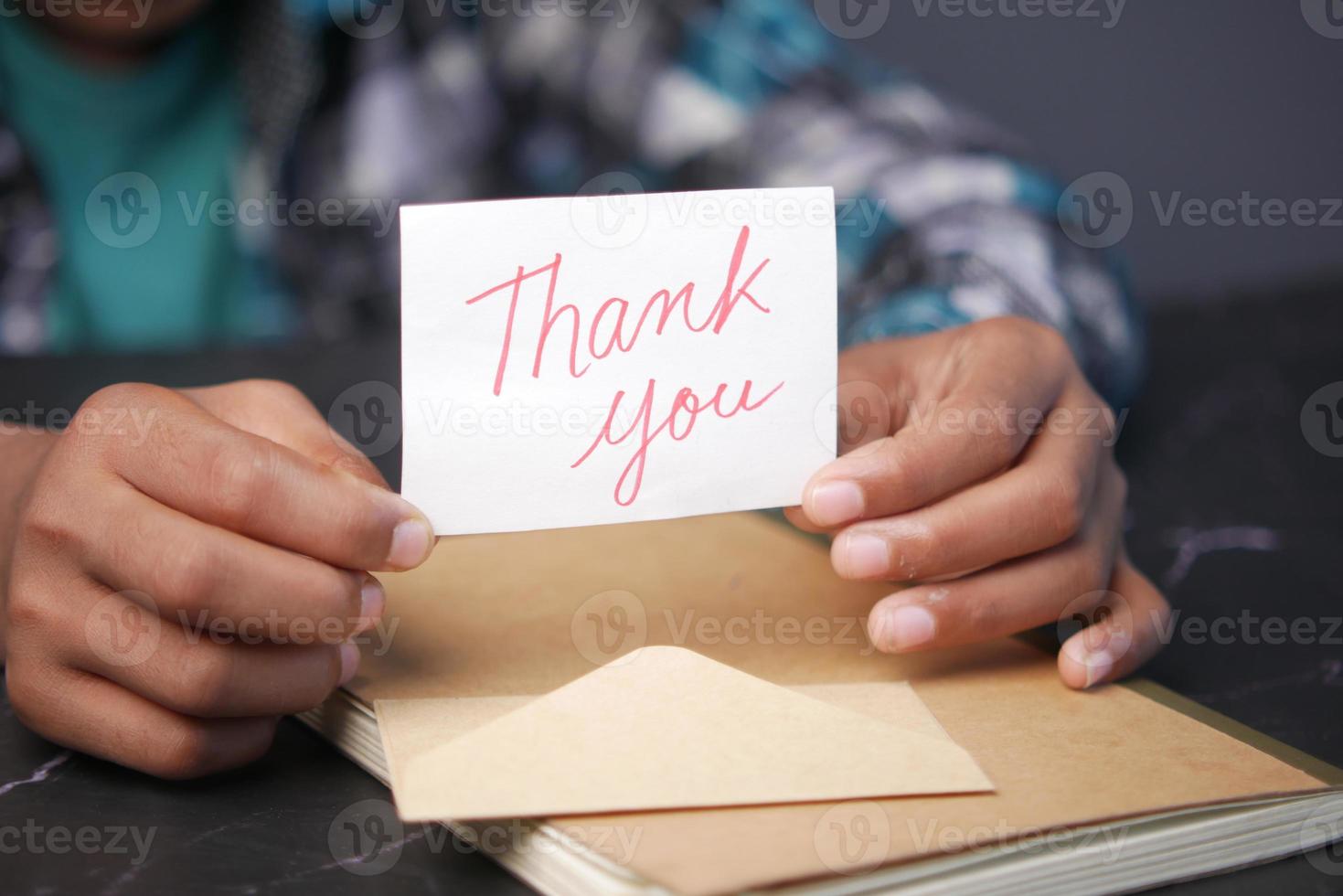 close up of man hand reading a thank you letter photo