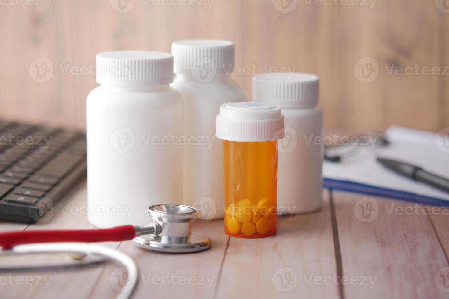 doctors workplace with container, keyboard and prescription on desk. photo